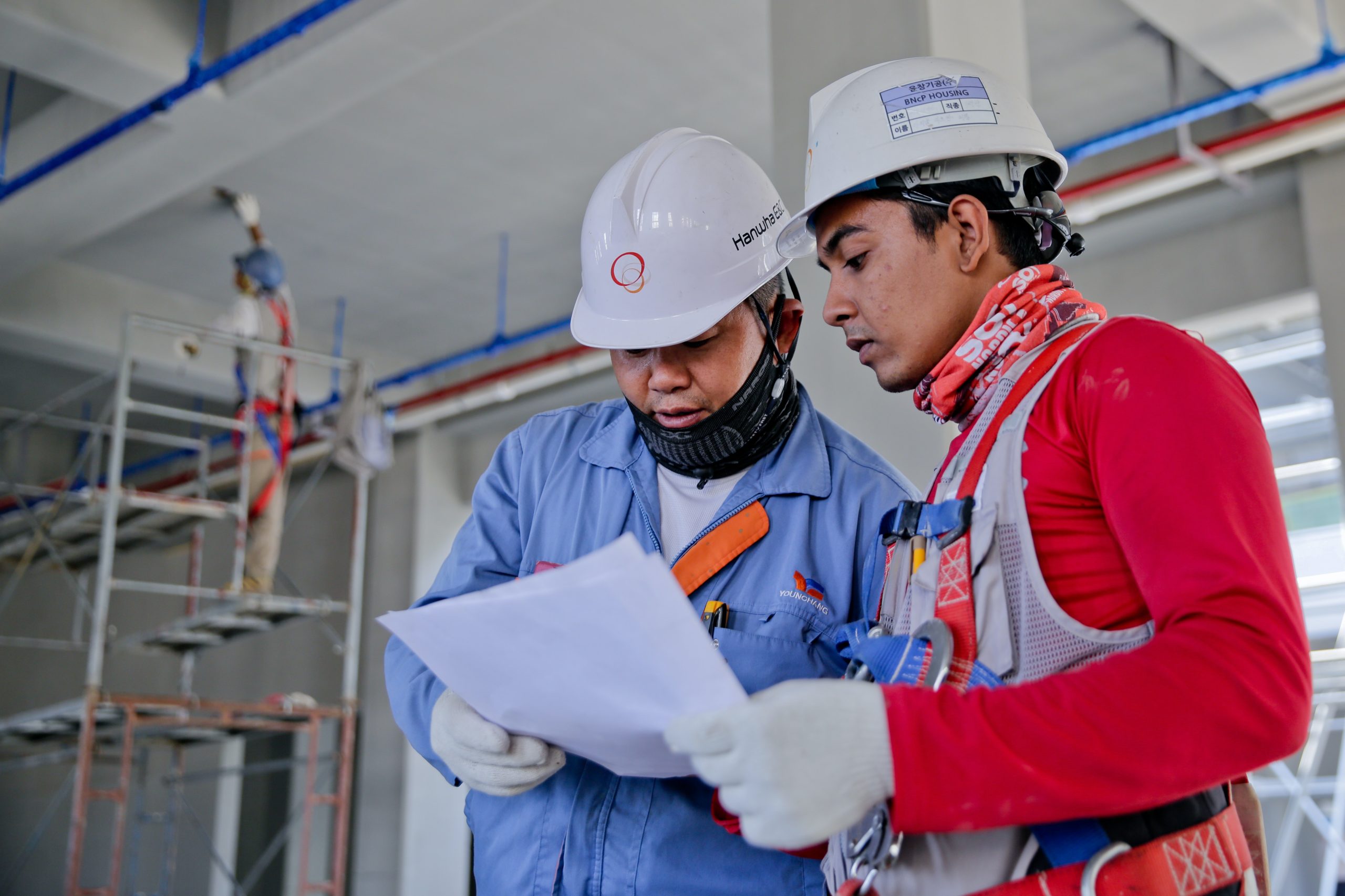 Two construction workers reviewing a document